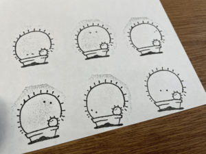 サボテンのイラストをハンコにして紙にスタンプした。6種類並んでいる。小さな目がついていて、子供サボテンも植っている。が可愛い